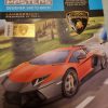 A "Design Masters" Lamborghini Aventador LP 700-4 sketchbook cover, featuring an orange car illustration, a gold hologram authenticity sticker, and the Lamborghini crest.