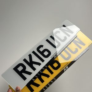 Pair of reflective and Number Plates held by hand, with the registration RK16 UCN and Kayenn Prestige